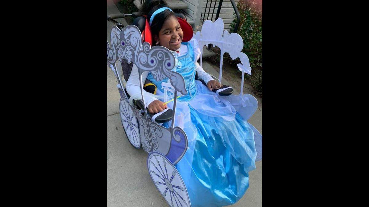 In this undated photo provided by her family, Genevieve “GG” Grayson is a princess, her wheelchair transformed into her royal carriage.