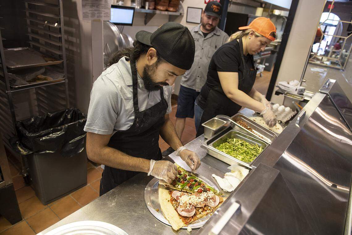 General Manager Hugo Zuniga and Alyssa Zuniga prepare pizza slices during lunch at Stuart’s Pizza on 10th Street in Modesto, Calif., on Tuesday, May 26, 2020.