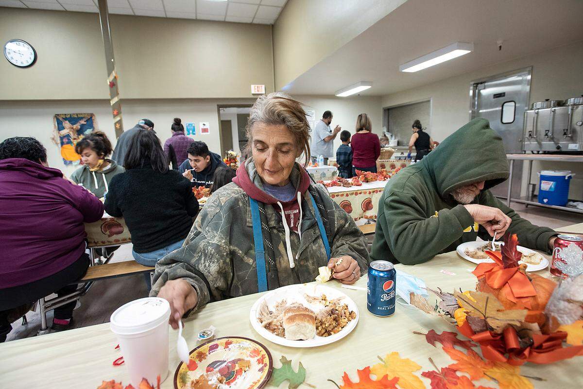 Susie and Robert Gibbs eat a holiday meal during the Great Thanksgiving Banquet & Bundle-Up at the Modesto Gospel Mission in Modesto, Calif., on Wednesday, Nov. 24, 2021.