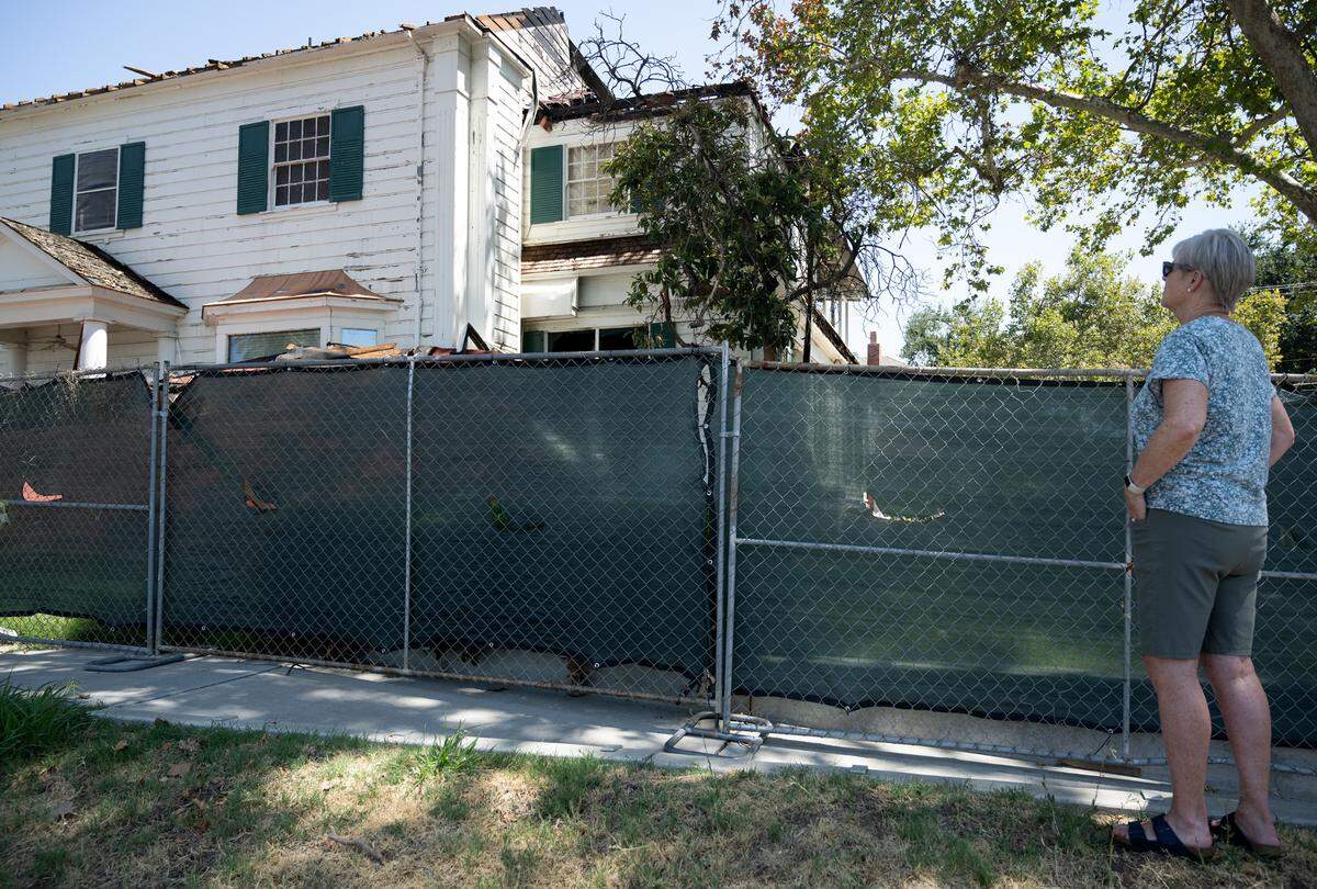 Judi Downing looks at the fire damaged former Franklin Downs funeral home on 12th Street in Modesto, Calif., Tuesday, July 23, 2024. Downing previously worked at the funeral home.