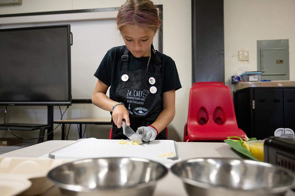 Gracyn Rands minces garlic as part of the Junior Chef after school program at Sipherd Elementary School in Modesto, Calif., Thursday, Sept. 19, 2024.