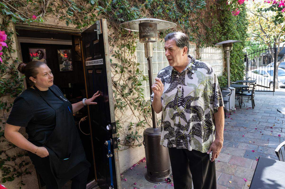 Vinny Altadonna, right, and Kimberly Altadonna, left, talk outside on the patio at Chefs of New York Italian restaurant in Modesto, Calif., on Friday, July 9, 2021. The restaurant has moved to a larger space on 13th Street with a full bar and patio.