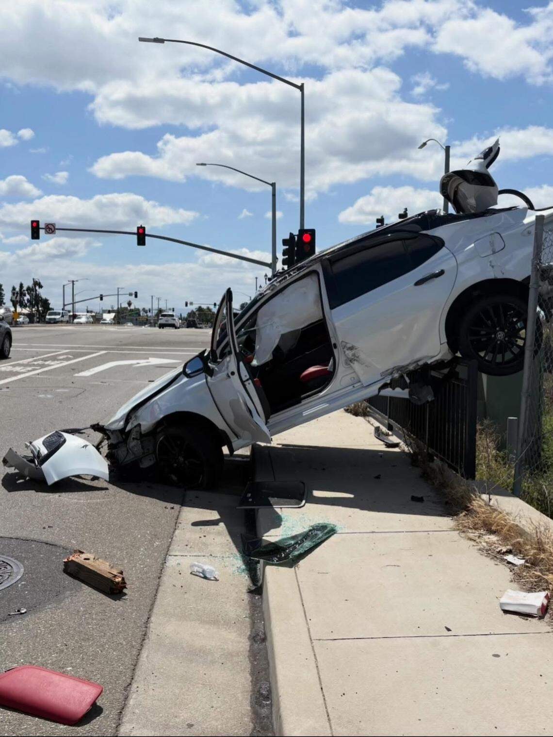 A Toyota Camry is seen upended on a fence along Kiernan Avenue after the driver lost control while exiting Highway 99, leading to a collision with another vehicle, CHP said.
