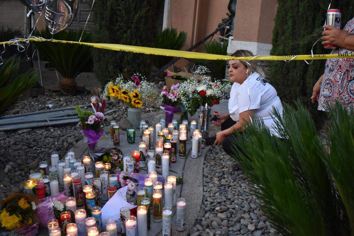 Mourners gather Wednesday night, June 30, 2021, outside a home on El Sereno Street in southwest Modesto where a fire that morning killed a mother and her 17-year-old son. Three other family members are expected to recover, according to police.