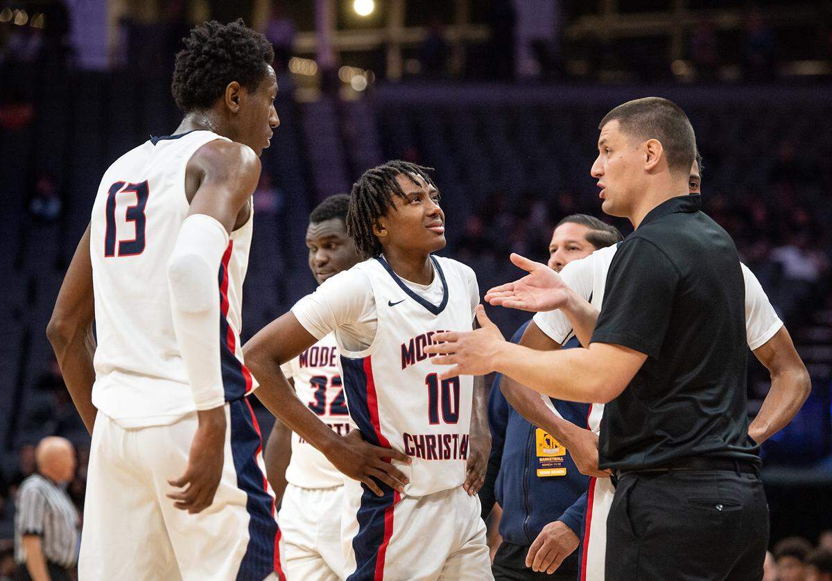 Modesto Christian coach Brice Fantazia, right, talks with Prince Oseya (13) during a timeout in the boys Open Division CIF State Basketball Championship game with Centennial at Golden 1 Center in Sacramento, Calif., on Saturday, March 12, 2022.