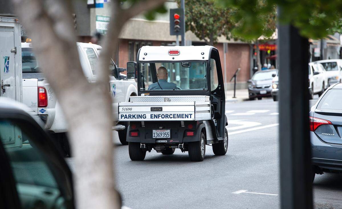 A parking enforcement team member patrols on 11th Street in Modesto, Calif., on Wednesday, Oct. 6, 2021.