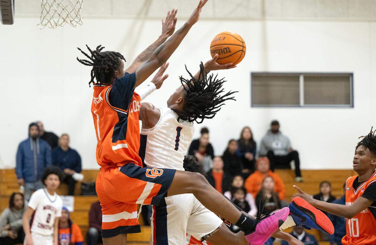 Modesto Christian’s Jeremiah Bernard challenges Jay Washington at the basket during the Sac-Joaquin Section Division I playoff game with Cosumnes Oaks at Modesto Christian High School in Salida, Calif., Wednesday, Feb. 14, 2024.