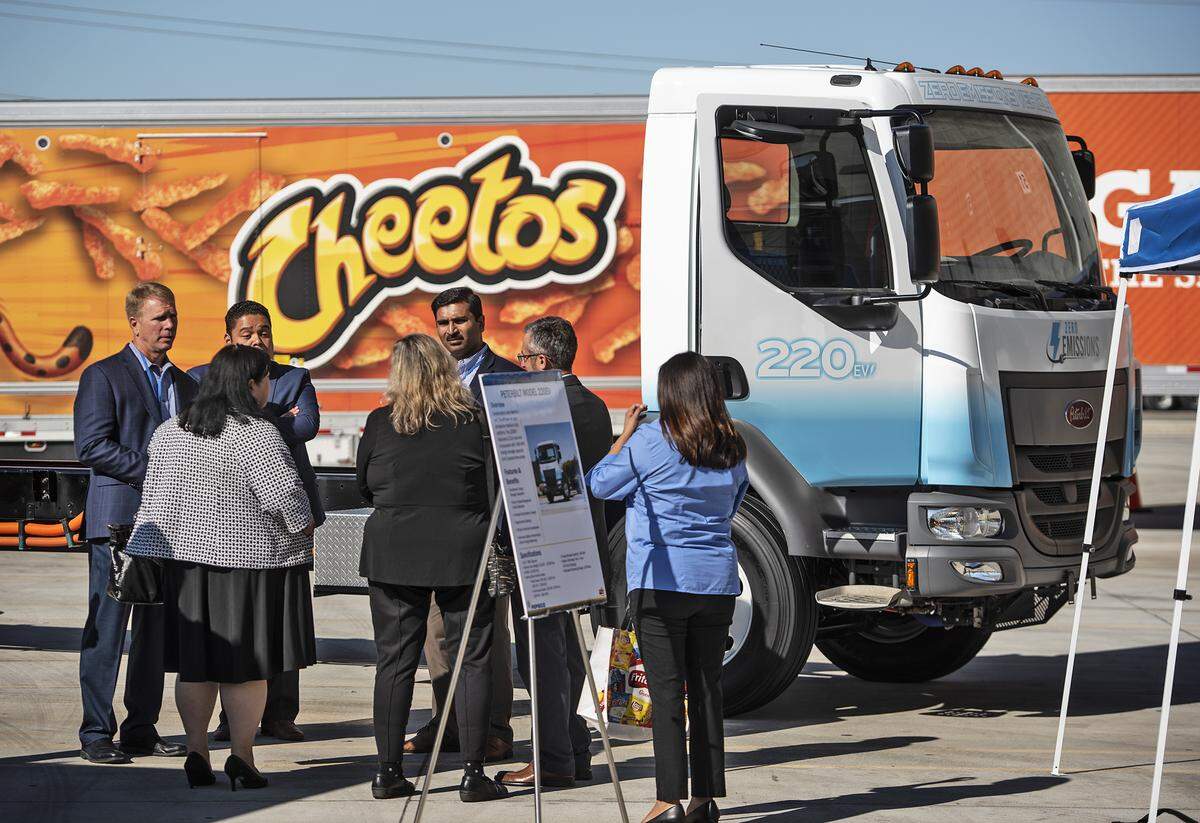 Visitors look at the electric box truck at the Frito Lay plant where the company announced that it will use an entirely sustainable fleet of vehicles at their Modesto plant in Modesto, Calif., Thursday, Oct. 3 , 2019. The Modesto plant will use electric Tesla semi trucks and other production vehicles as part of a $30 million project to convert its entire diesel fleet to sustainable vehicles.