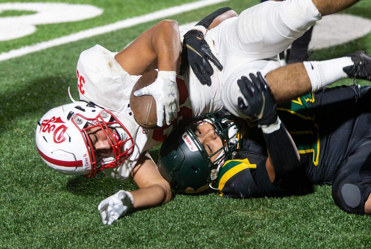 Isaac Vizcarra, 33, of Ceres High gets taken down by Chris Munoz, 14, of Davis High during a WAC game against Davis High on Friday Oct. 27, 2023.
