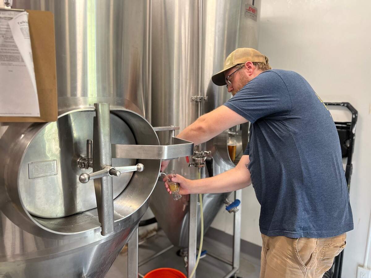 Brethren head brewer Kevin Whitehouse pours a taste of an IPA that’s been in the brew process for three weeks.