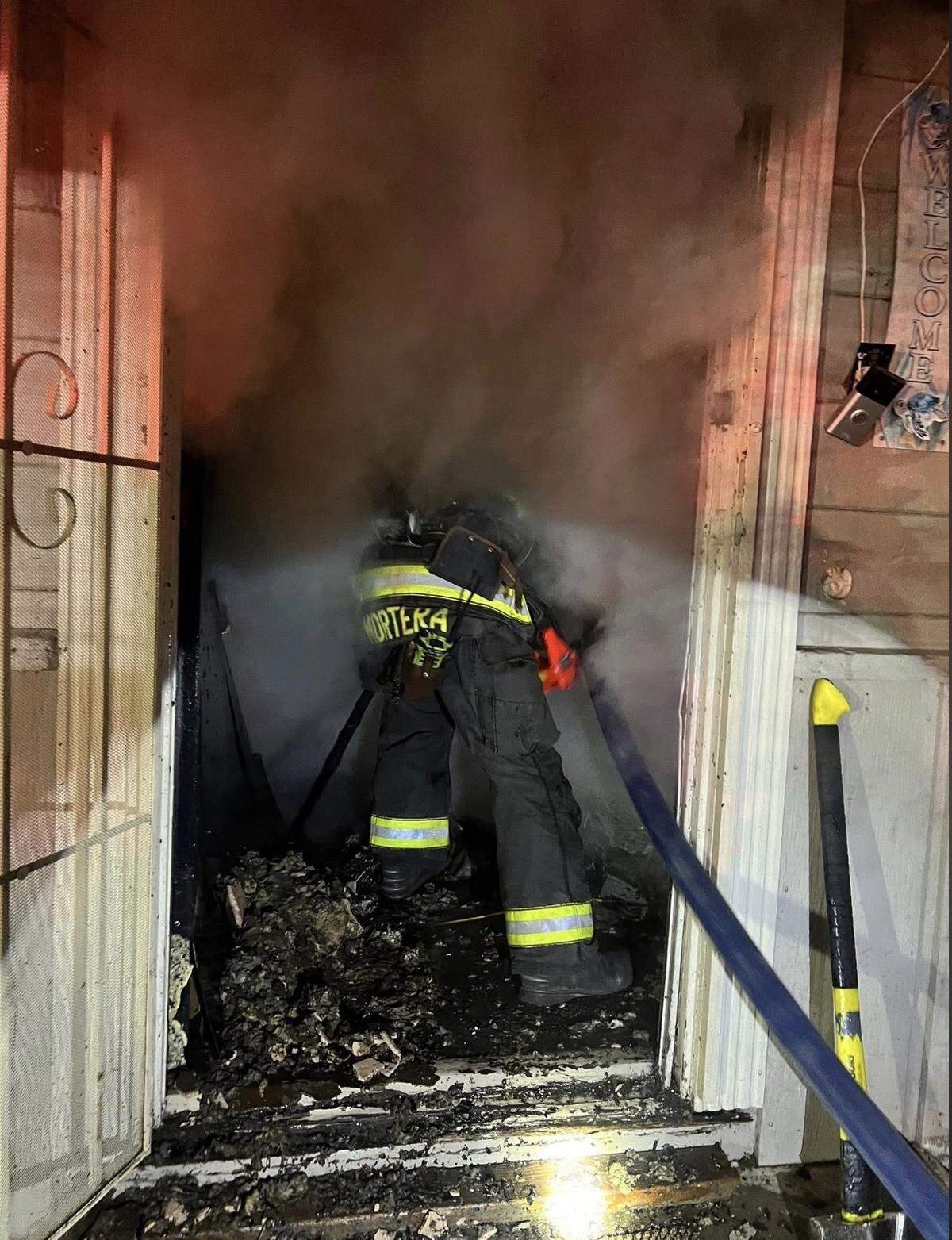 A firefighter works inside a smoke-filled structure as crews battle an early-morning arson fire in the 900 block of Wayside Drive in Turlock. Fire officials said two structures on the property were burning when crews arrived.