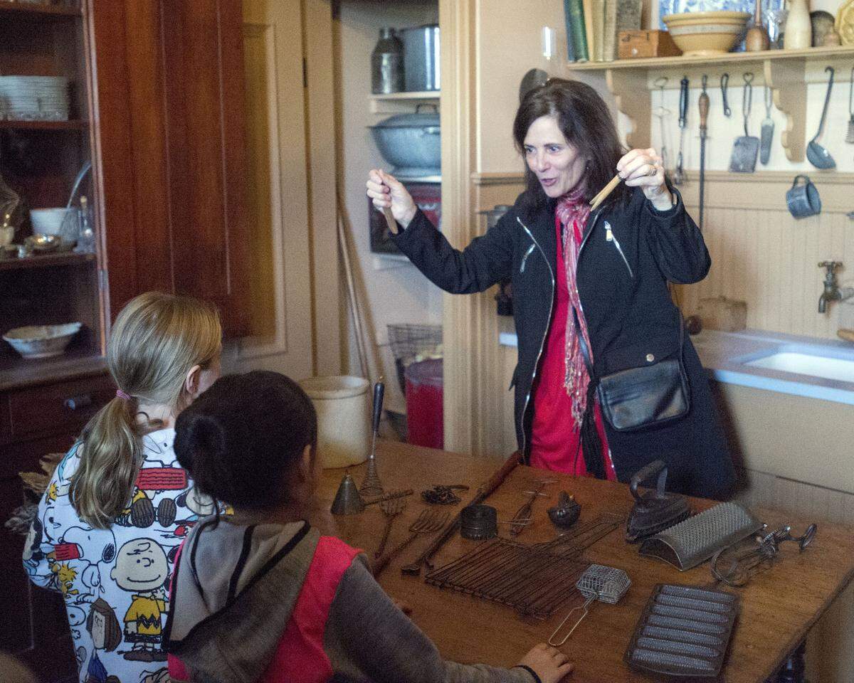 Lani Turner, a McHenry Mansion docent explains how old kitchen tools worked during the Dickens Faire in Downtown Modesto on December 1, 2018. 