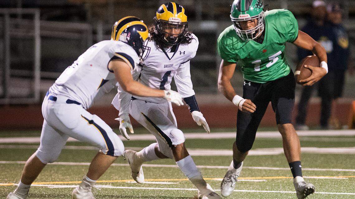 Pitman’s Peyton Bass runs up against Gregori defenders Jared Hughes and Marcello Longstreth during the CCAL game at Joe Debely Field in Turlock, Calif., on Friday, Oct. 5, 2018.