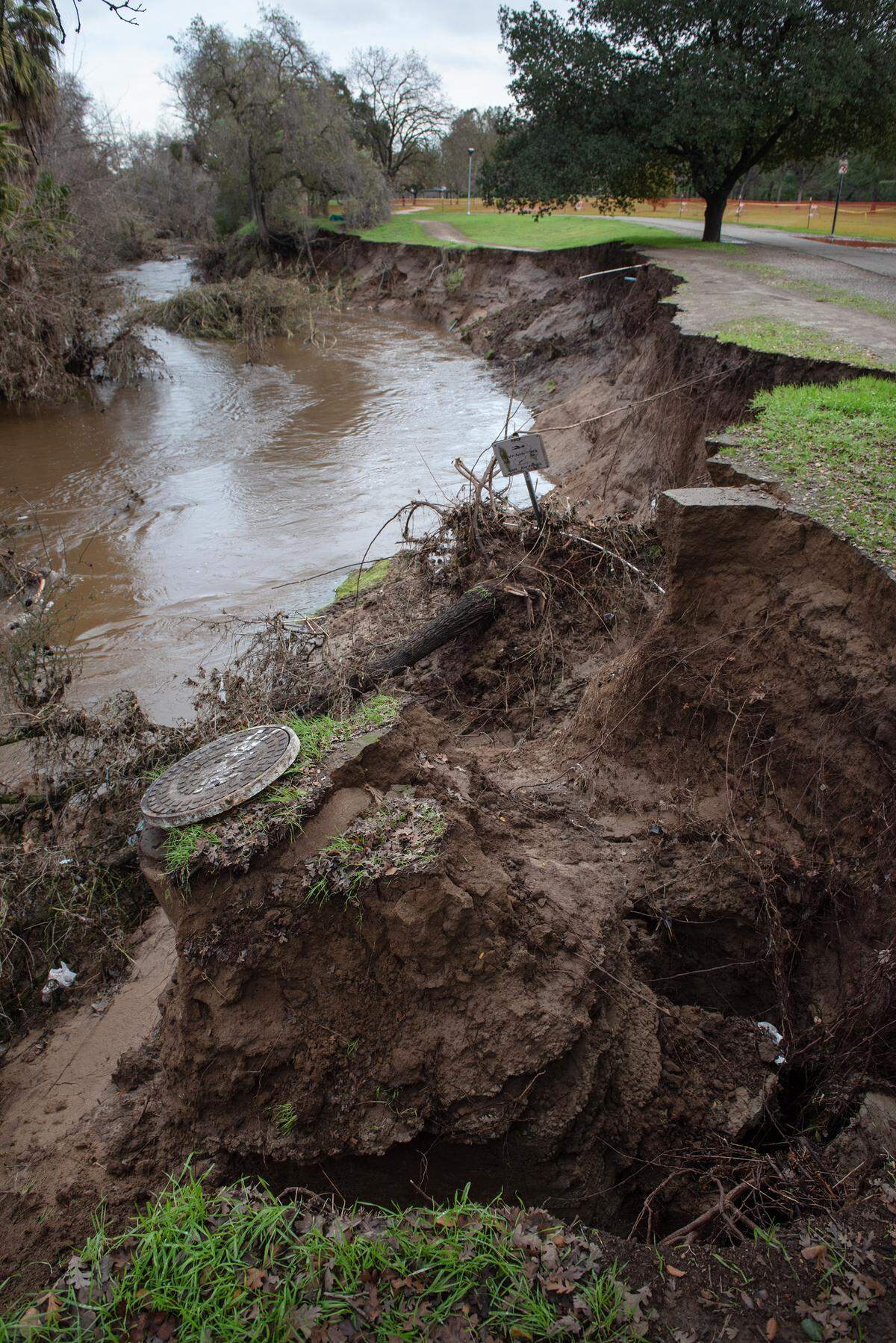 High water from the weekend storm damaged the bank along Dry Creek at East La Loma Park in Modesto, Calif., Friday, Jan. 3, 2023.