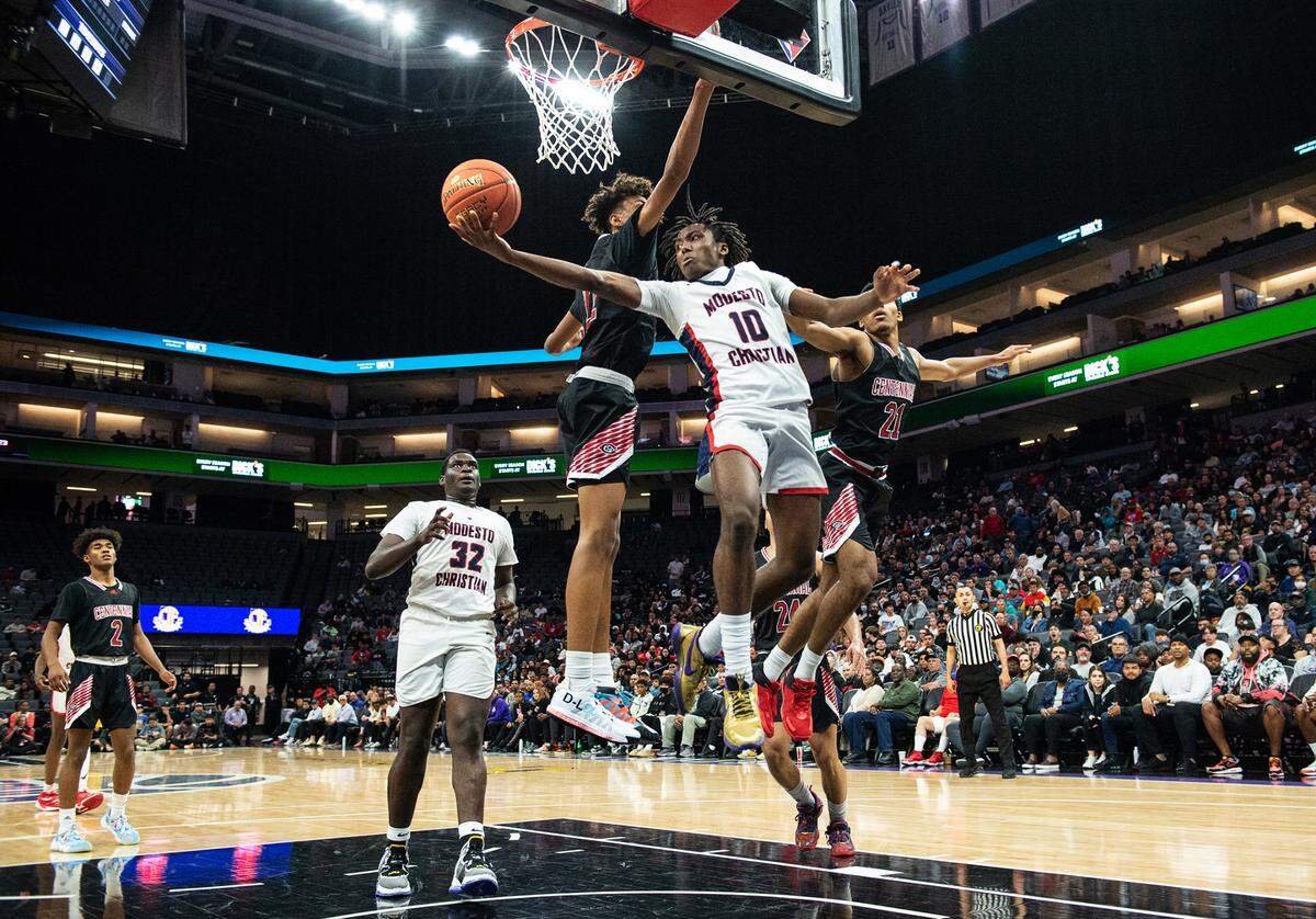 Modesto Christian’s BJ Davis fakes a layup and passes the ball during the boys Open Division CIF State Basketball Championship game with Centennial at Golden 1 Center in Sacramento, Calif., on Saturday, March 12, 2022. Centennial won the game 59-50.