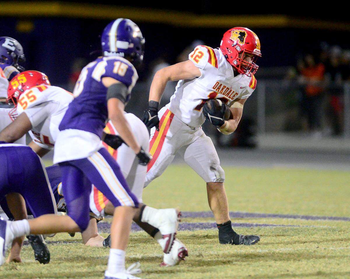 Oakdale running back Wes Burford (12) breaks through the line for a long run during a game between Escalon High School and Oakdale High School in Escalon, Calif. on Sept. 6, 2024. Oakdale won the game 21-20 in overtime.