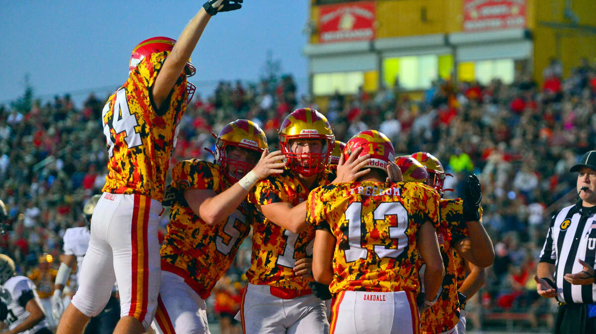 Oakdale teammates celebrate with Kevin Camelin (13) after scoring a touchdown during a football game between Oakdale High School and Archbishop Mitty High School at Oakdale High School in Oakdale California on September 10, 2021.