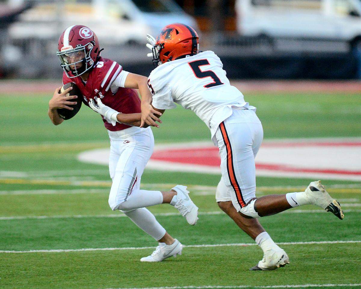 Patterson quarterback Max Medina (3) scrambles away from a Merced defender during a game between Patterson High School and Merced High School at Patterson High on Aug. 23, 2024.