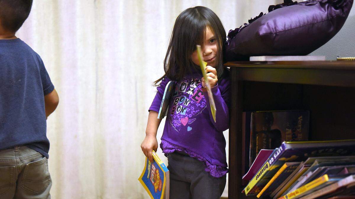 Luna 3yrs picks out books to look at Monday afternoon November 5, 2018 at Family Promise of Greater Modesto in Modesto, Calif.