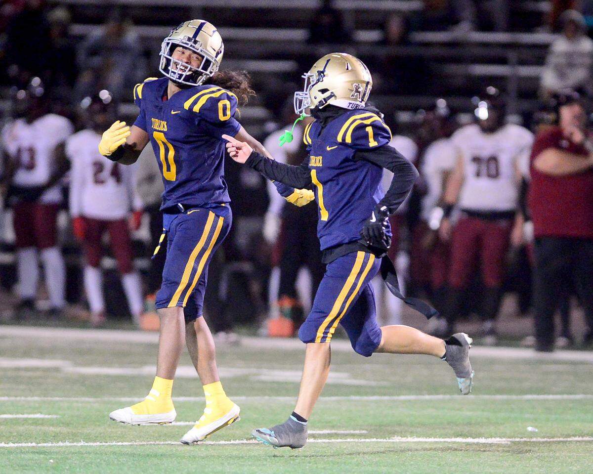 Turlocks Jeremiah Stine (0) and Junior Silva (1) celebrate Silva scoring a touchdown during a Division 1 CIF San-Joaquin Section playoff game between Turlock High School and Laguna Creek High School at Turlock High School in Turlock California on November 8, 2024. Turlock won the game 48-12.