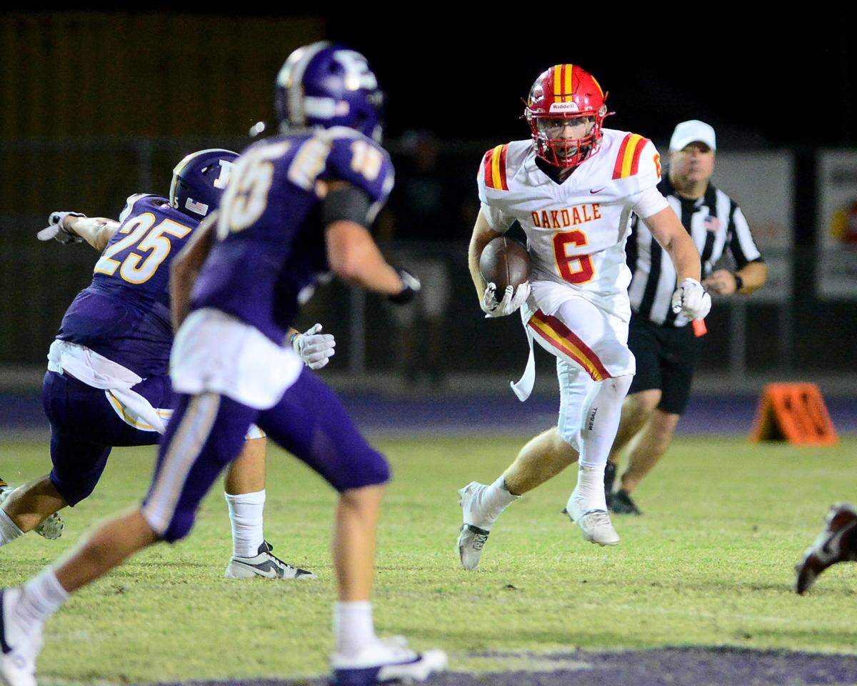 Oakdale’s Chase Lopez (6) eyes Escalon defenders on a sweep during a game between Escalon High School and Oakdale High School in Escalon, Calif. on Sept. 6, 2024. Oakdale won the game 21-20 in overtime.