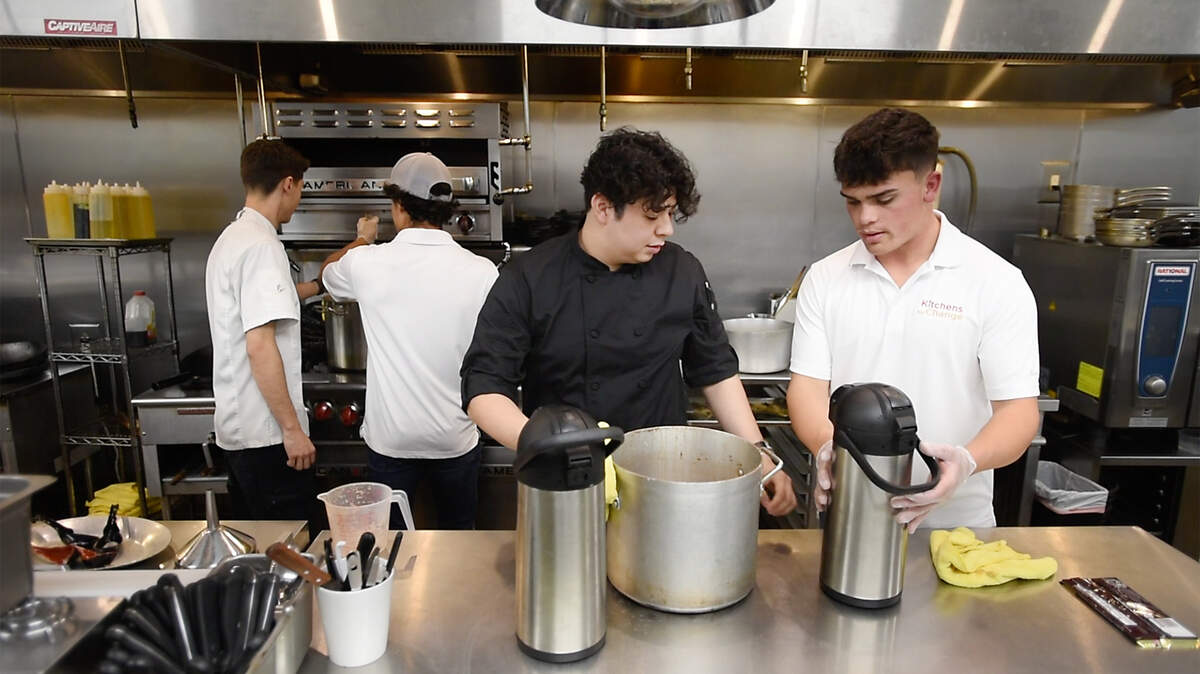 Griffen Sotomayor, a la derecha, y el chef Néstor Jacobo preparan chocolate caliente durante una reunión del club Kitchens for Change en Turlock, California, el lunes 8 de noviembre de 2021.
