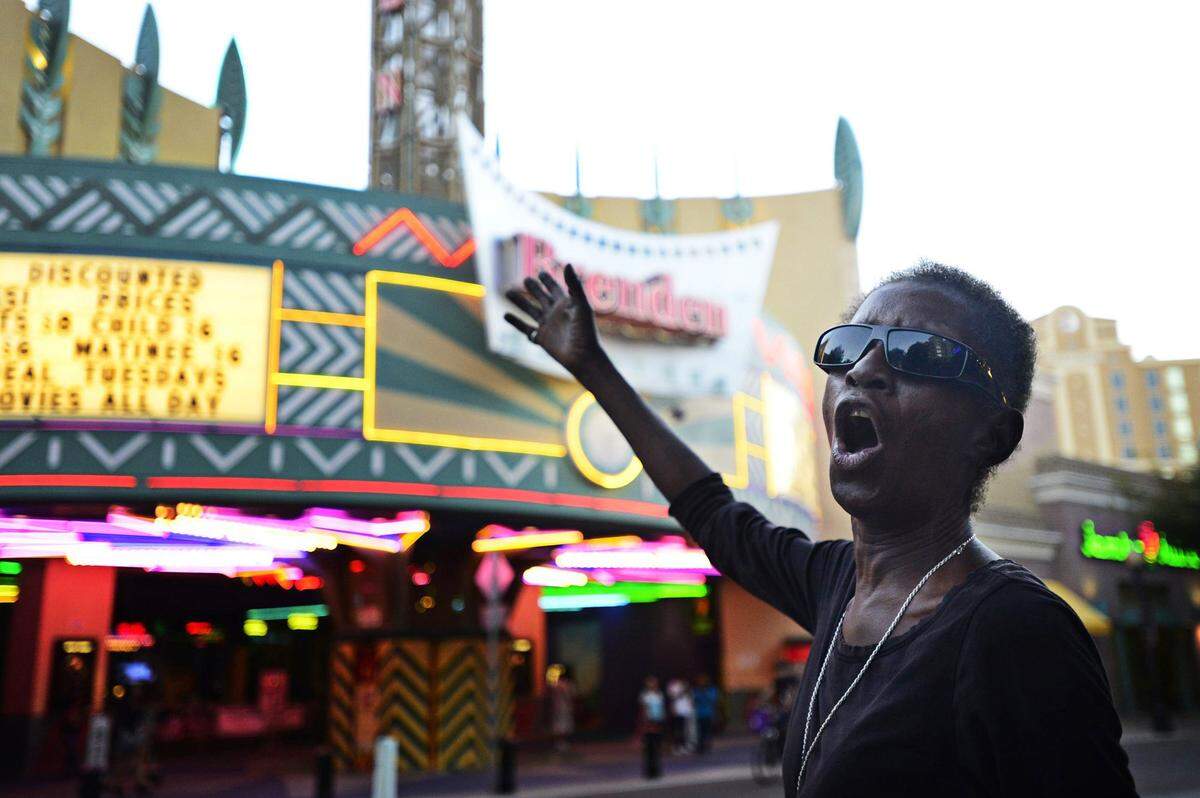To collect enough donations to afford a motel room, Dellanora Green sings ‘Amazing Grace’ outside Brenden Theatres in downtown Modesto, Calif., Sunday, Oct. 5, 2014. She died on Christmas Eve.
