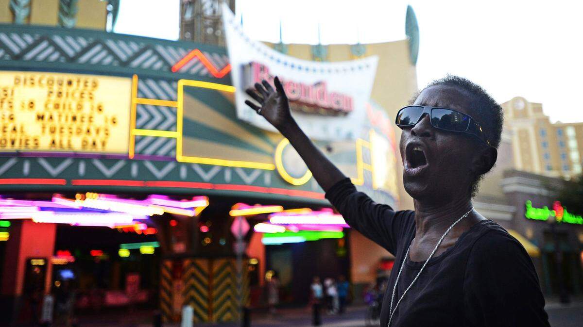 Dellanora Green sings ‘Amazing Grace’ in an attempt to collect enough donations to afford a hotel room outside the Brenden Theatre in downtown Modesto, Calif., Sunday, Oct. 5, 2014. She died on Christmas Eve.