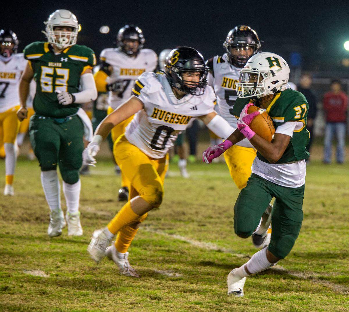 Nathan Ayala, 27, of Hilmar High works his way up field as Colt Foss, 0, of Hughson High closes in during the Trans-Valley League game against Hughson in Hilmar, Calif. on Friday Oct. 25, 2024.