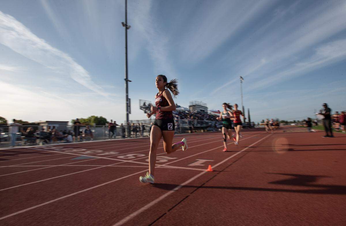 Modesto’s Melissa Barajas starts the final lap of the girls 1,600 meter race during the Stanislaus County Championships on Friday, March 18, 2022, at Riverbank High School in Riverbank, Calif. Barajas won the race.