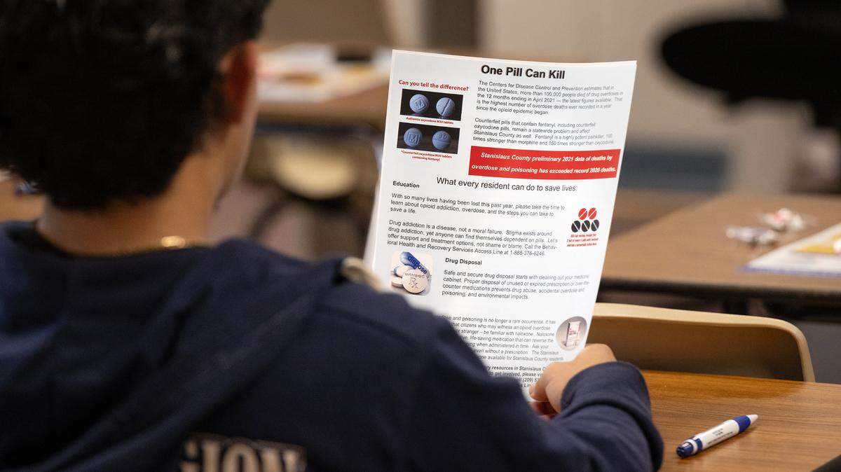 A student looks at a flier about counterfeit prescription drug laced with fentanyl during a presentation at Elliott Alternative Education Center school in Modesto, Calif., Wednesday, Oct. 25, 2023.