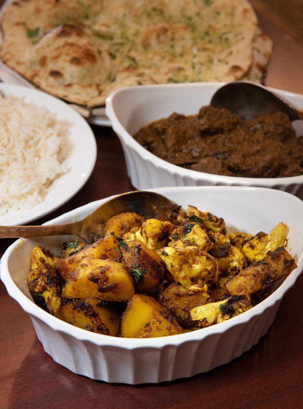 Aloo Gobhi (califlower and potatoes), with lamb curry, rice and garlic naan at Tandoori Masala in Modesto, Calif., Thursday, Dec. 8, 2022.