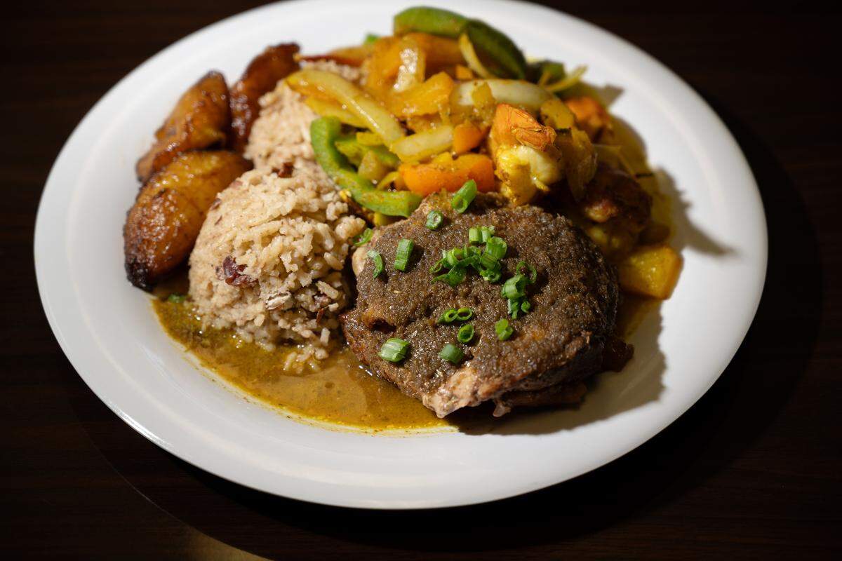 Caribbean combination dish of jerk chicken and curry shrimp served with rice and plantains at Cariblue restaurant on Yosemite Boulevard in Modesto, Monday, Oct. 14, 2024.