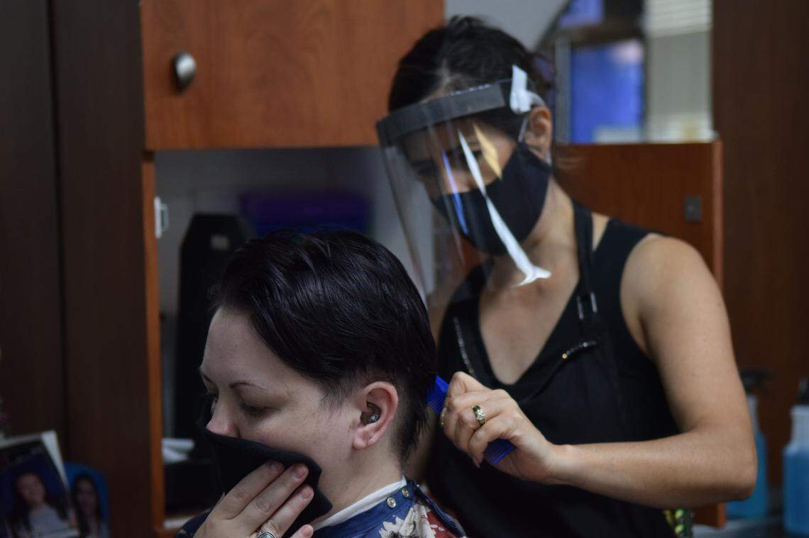 Stylist Humbelina Oliver (right) cuts Tiffany Helms’ hair at Hair Dynamix in Ceres, California on Thursday, May 28, 2020. Helms said she called the salon to make an appointment right after the state announced salons could open after being closed due to the coronavirus pandemic.