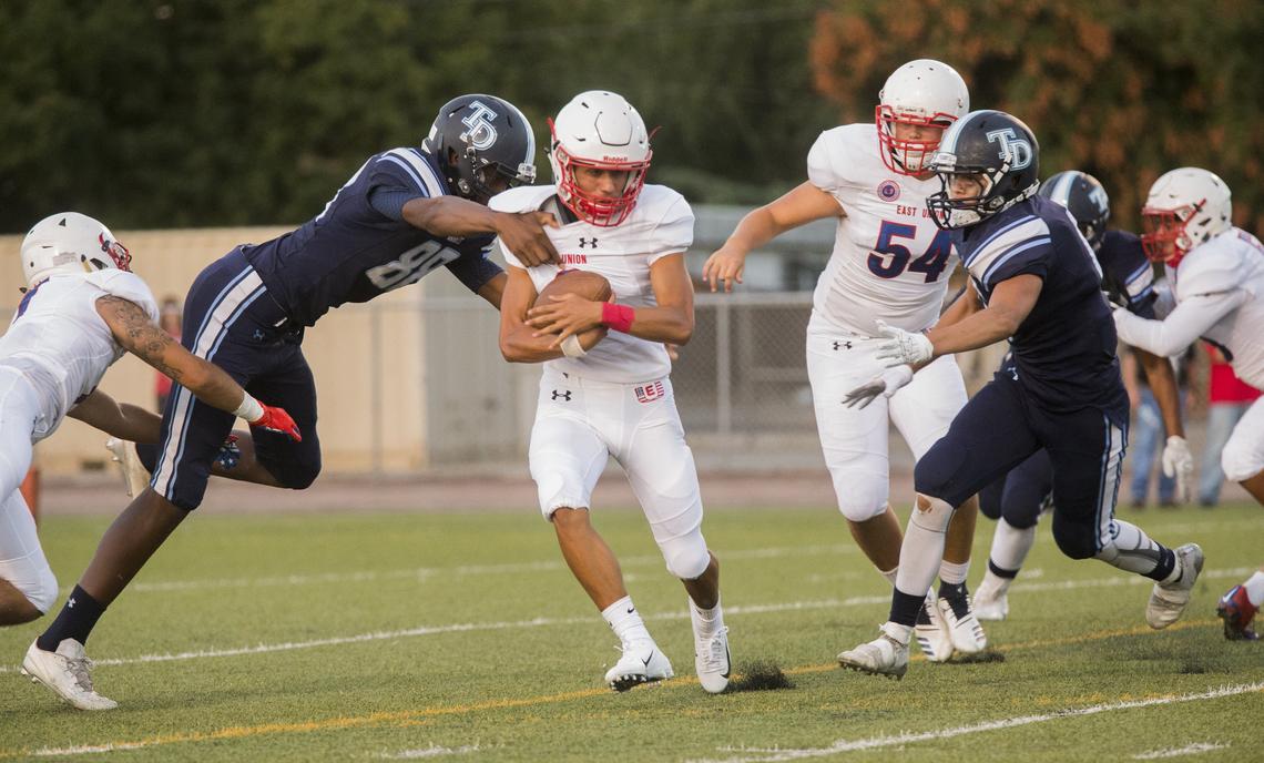 Marquise Higgins, 8, tries to gain some yards between Downey High defense. Downey High took on East Union Friday Aug. 17, 2018.