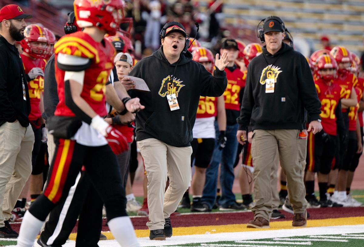 Oakdale coach Garrett Martin, middle, calls out to his players during the Sac-Joaquin Section Division 3 championship game with Vanden at Sacramento City College in Sacramento, Saturday, Nov. 30, 2024.