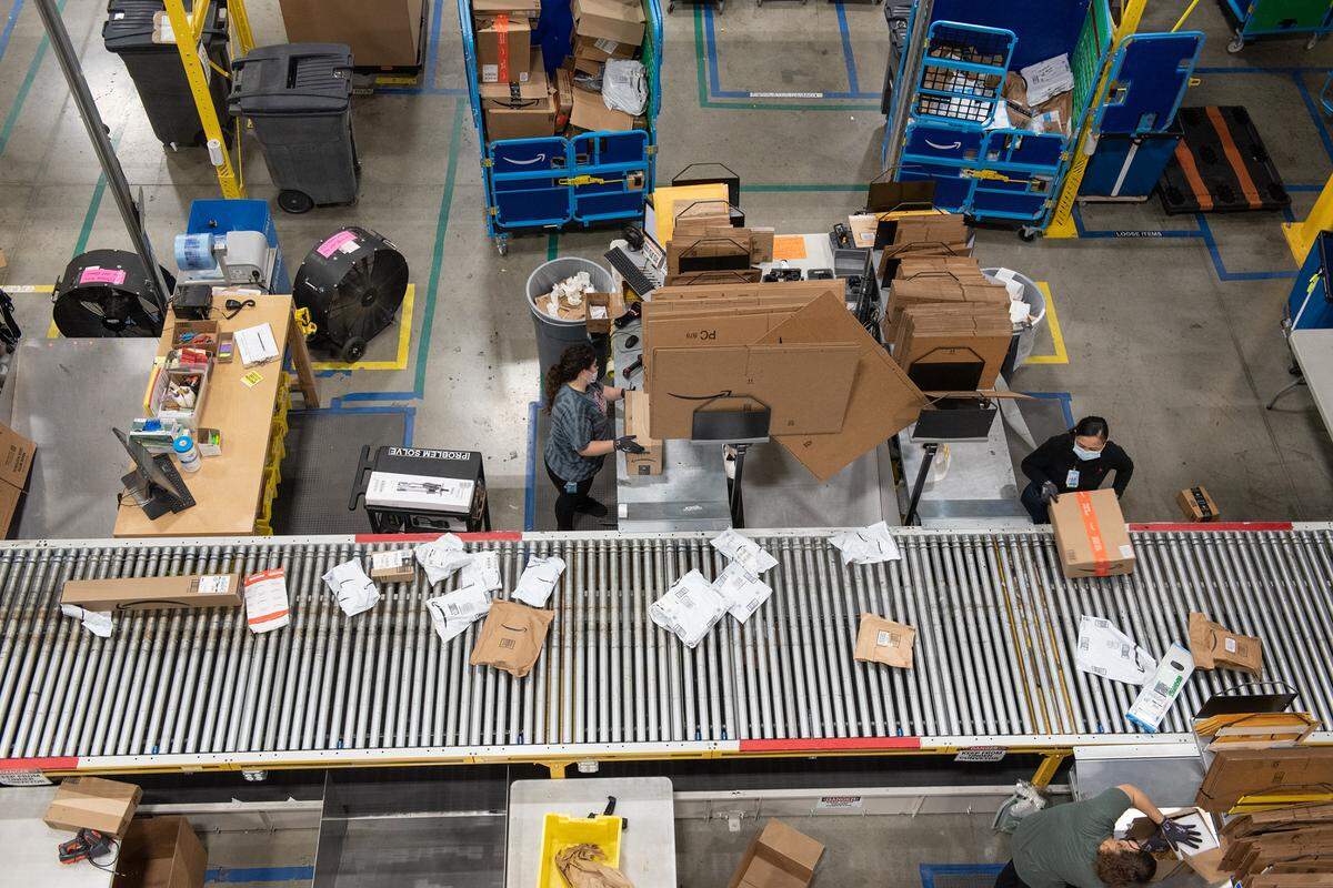 Workers process items at the Amazon robotic sort center in Tracy, Calif., Thursday, Nov. 10, 2022.