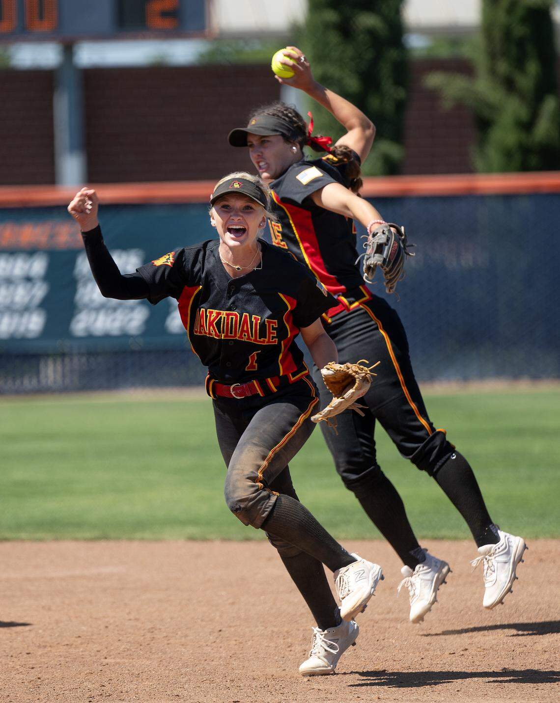 Oakdale’s Jayci Volonte (1) and Madi Bohannon celebrate the final out to win the Sac-Joaquin Section D III softball championship game over Capital Christian at Cosumnes River College in Sacramento, Calif., Saturday, May 25, 2024.