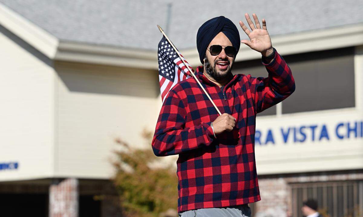 Stanislaus County Supervisor Mani Grewal waves to the crowd during Veterans Day Parade in Modesto, Calif., Saturday, Nov. 11, 2023.