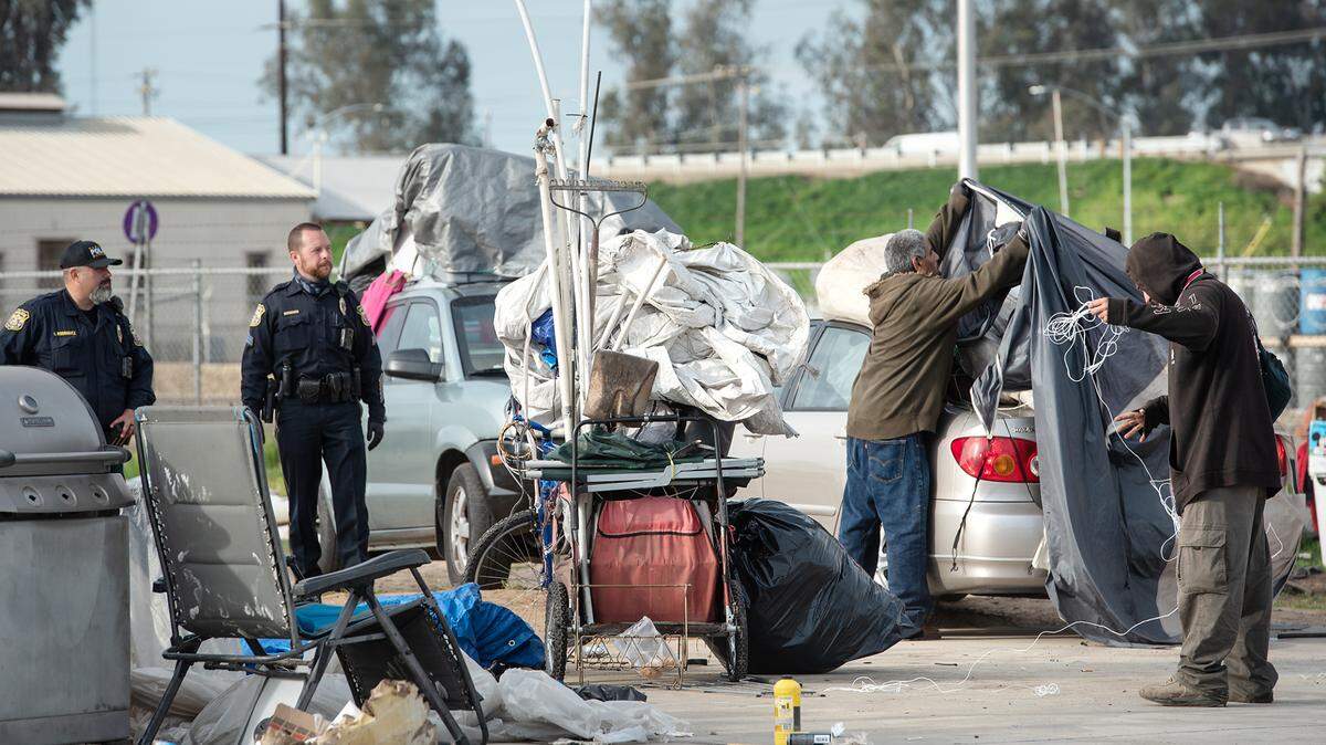 Turlock police enforce a trespassing notice and sweep the homeless from an encampment on West Main Street in Turlock, Calif., on Thursday, March 18, 2021.
