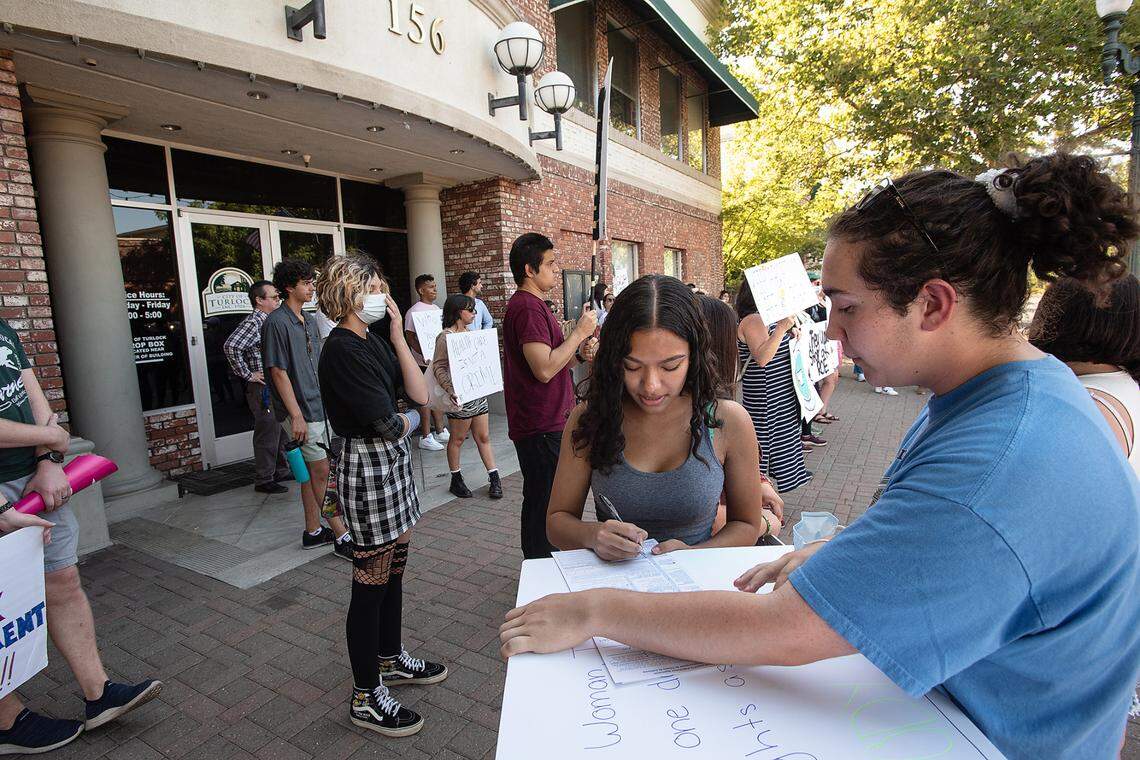 Serenity Janoras, 16, pre-registers to vote with rally organizer Micah Littlepage, right, during an abortion rights rally outside Turlock City Hall in Turlock, Calif., on Tuesday, June, 28, 2022.