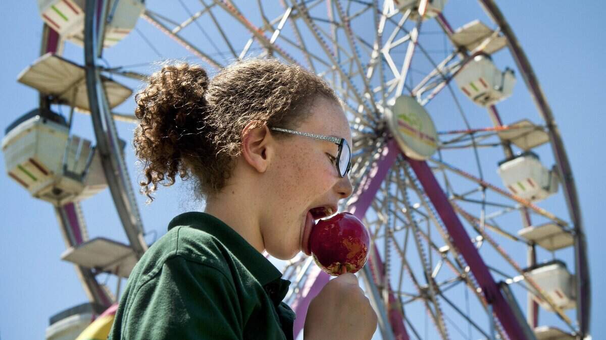 Ashley Bucher, 11, of Woodland samples a candy apple at the Yolo County Fair in 2012. The 2020 fair was canceled due to coronavirus.