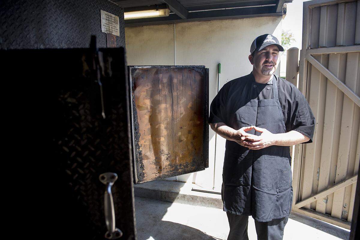 Chef and owner Steve Ceron stands next to his large smoker at his barbecue restaurant at Almond Wood in Patterson, Calif., on Thursday, May, 26, 2016.
