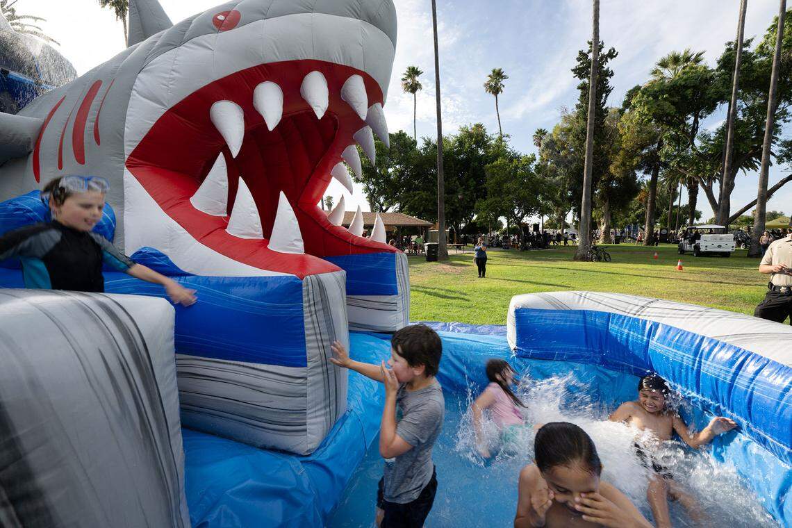Kids play on the waterslide during National Night Out at North Park in Patterson, Calif., Tuesday, August 1, 2023.