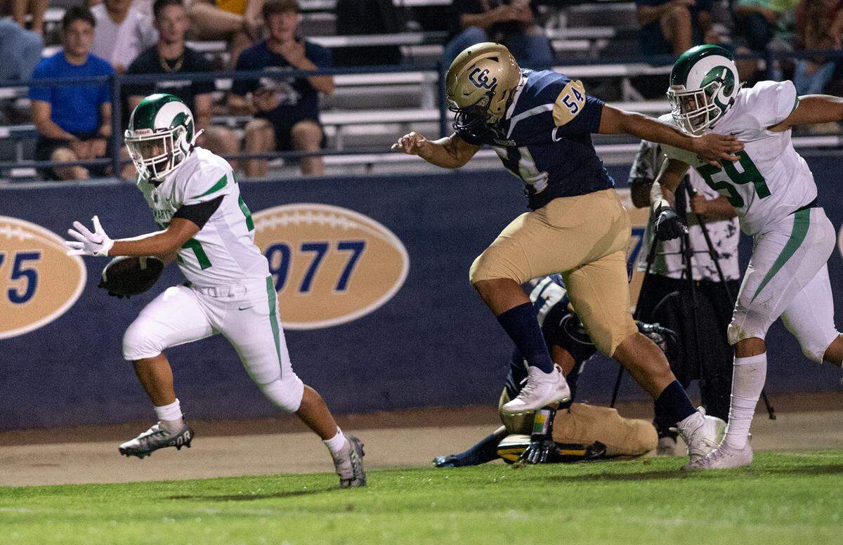St. Mary’s L J Parafina, left, slips tackles and runs for a touchdown in the third quarter during the non-league game with Central Catholic at Central Catholic High School in Modesto, Calif., on Friday, September 2, 2022.