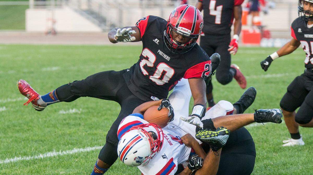 Gabe Ruiz, 4, of Beyer High gets taken down by Zaire Eugene, 20, of Modesto High and a teammate. Beyer High took on Modesto High during high school football Friday Aug. 24, 2018