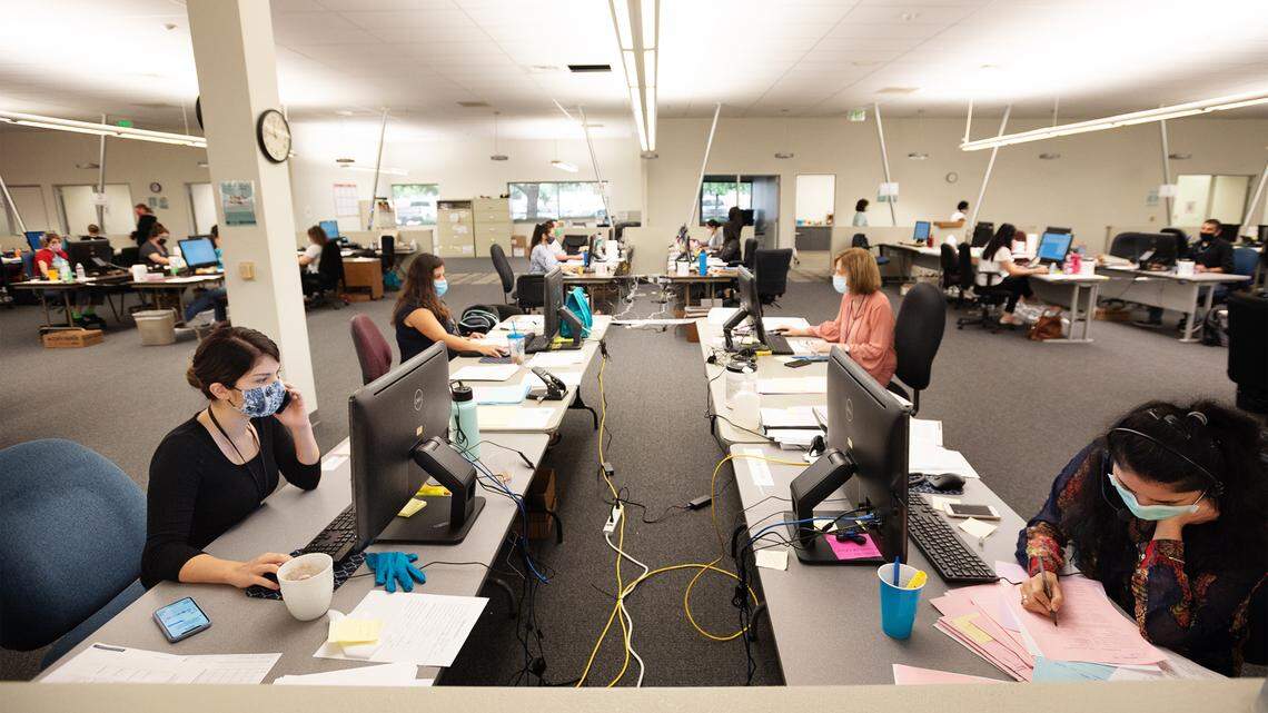 Tiawny Murphy, left, and Alekha Challa, right, work with other coronavirus case investigators at the Stanislaus County Emergency Operations Center in Modesto on Tuesday, July 21, 2020.