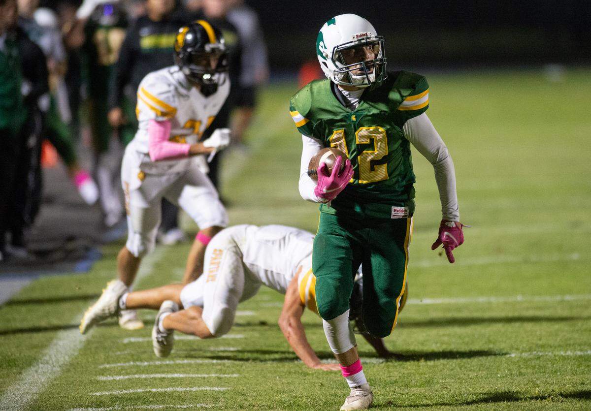 Davis’ Jose Sanchez breaks tackles and runs for a touchdown during the Western Athletic Conference game with Lathrop at Modesto Junior College in Modesto, Calif., on Friday, Oct. 8, 2021. Davis won the game 25-13.