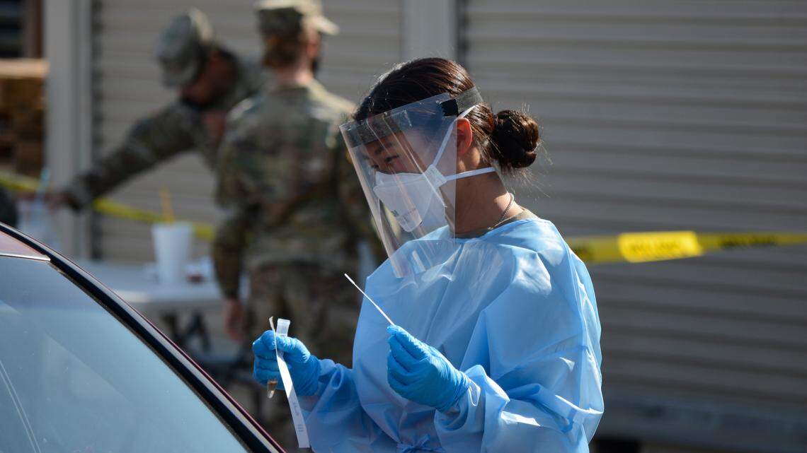 Army National Guard Specialist Seohyun Lee prepares to administer COVID-19 test at a testing site next to El Rematito Crows Landing Flea Market in Modesto, California on Friday, Oct. 16, 2020.
