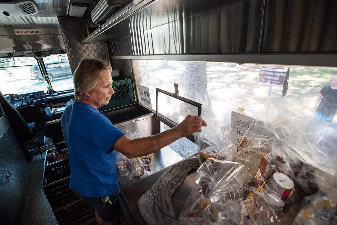 United Samaritans Foundation’s food truck supervisor Glenda Price hands out food during lunch at Mono Park in Modesto, Calif., on Friday, June, 24, 2022.